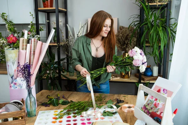 Una Florista Con Pelo Rojo Recoge Ramo Rosas Una Floristería Fotos de stock