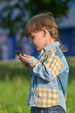 Küçük bir çocuk telefonu inceliyor. Burayı kim aradı??