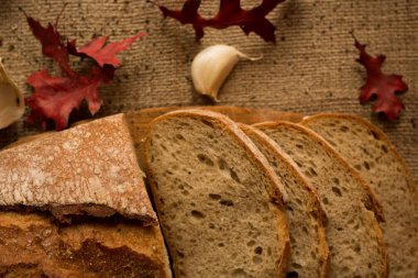 Sonbahar yaprakları ve sarımsak ile bileşiminde taze ekmek dilimlenmiş.