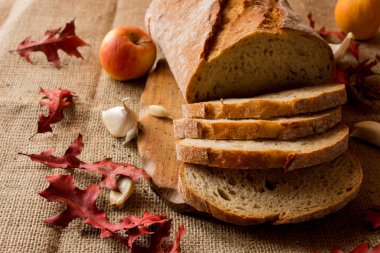 Sonbahar yaprakları ve sarımsak ile bileşiminde taze ekmek dilimlenmiş.