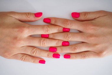 Genç bir kızın güzel elleri ve beyaz arka planda güzel bir manikür. Güzellik ve cilt bakımı konsepti, yakın plan..