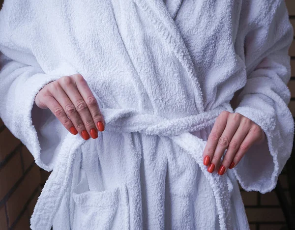 ホテルでの休息の概念 少女の美しい手は白いバスローブを編んだ 美しいマニキュア — ストック写真
