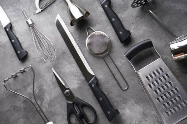 Gri masa arka planında çeşitli mutfak aletleri, yakın plan..