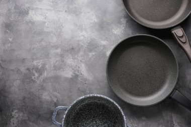 Tava seti. Gri masa zemininde çeşitli mutfak gereçleri, düz yatış, metin için yer.