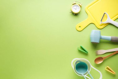 Açık yeşil zemin üzerinde mutfak gereçleri ve metin için yer var. Düz yatıyordu.