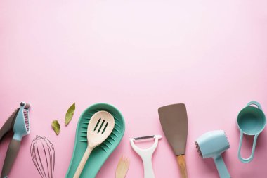 Pembe arka planda mesaj için yeri olan mutfak aletleri. Düz yatıyordu.