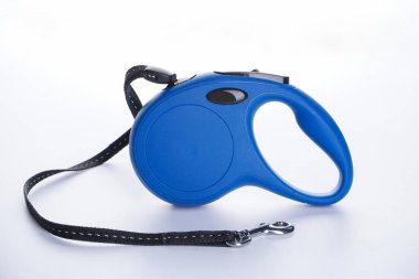 Beyaz arka plandaki köpekler için mavi geri çekilebilir tasma. Yakın plan..