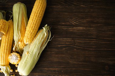 Tahta arka planda olgun mısır başakları, üst manzara. Metin için boşluk