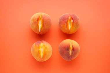 Turuncu arka planda taze şeftaliler, üst manzara. Seks konsepti