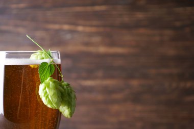 Ahşap arka planda bir bardak light bira, metin için yer.