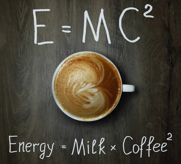 Süt ve iki formülleri ile siyah kahve fincan. Ahşap arka plan.