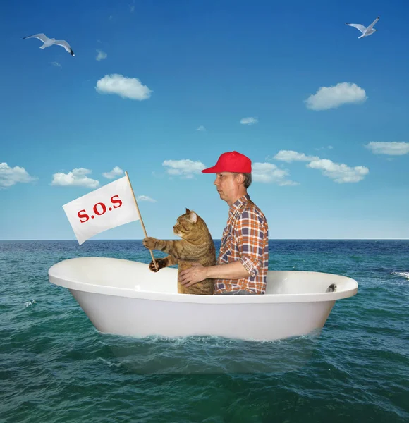 Muž s kočkou unášené mořem — Stock fotografie