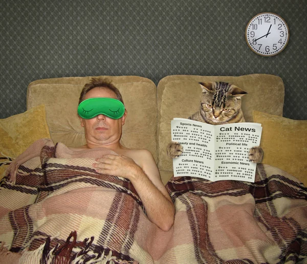 Bărbat și pisică cu ziar în pat — Fotografie, imagine de stoc