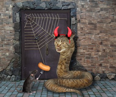 Şeytan boynuzlu bej kedi yılanı ve çatallı siyah sosisli fare Cadılar Bayramı için eski bir şatonun kapısını koruyorlar..