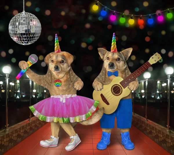 Two dog unicorns musicians are singing a song near a disco ball on stage in a nightclub.