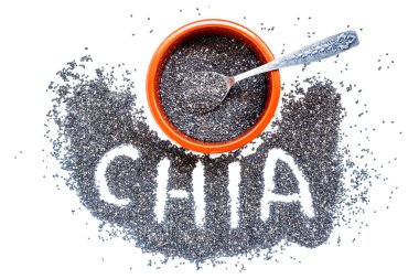 Chia tohum bir seramik kase ve küçük bir gümüş kaşık. Beyaz izole. 