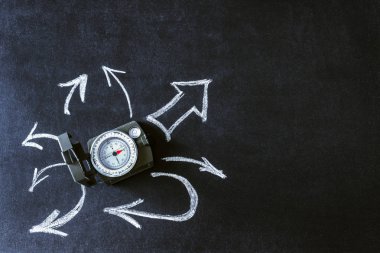 Siyah arka plan üzerine oklar arasında pusula. Kavram-karar verme, seçim, seyahat, kariyer, hareket, yön. Kopya alanı.