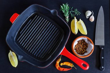 Siyah arka plan üzerine baharat ile boş ızgara tava. Kavram-yemek, menü, yemek tarifleri.