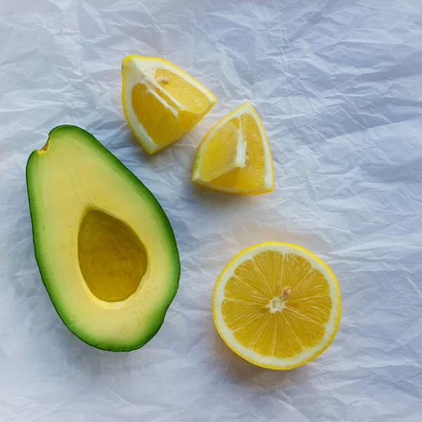 Reife Avocado Und Saftige Zitronenscheiben Auf Pergamentpapier Konzept Gesunde Ernährung — Stockfoto