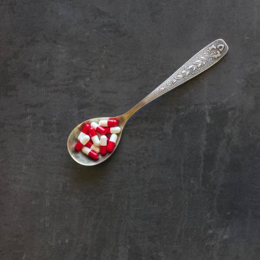 Bir sürü hap ve karanlık bir arka plan üzerine bir kaşık vitamin. Kavram-eczane, gıda katkı maddeleri, kötüye kullanımı ve bağımlılığı ilaç ilaçlar, uyuşturucu bağımlılığı.