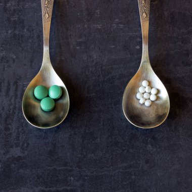Bir sürü hap ve karanlık bir arka plan üzerine bir kaşık vitamin. Kavram-eczane, gıda katkı maddeleri, kötüye kullanımı ve bağımlılığı ilaç ilaçlar, uyuşturucu bağımlılığı.
