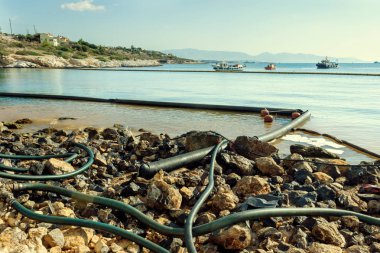 Petrol sızıntısı. Çevre felaketi. Kapsama patlaması, petrol sızıntısını kontrol altında tutmak için kullanılan geçici yüzen bir bariyerdir..