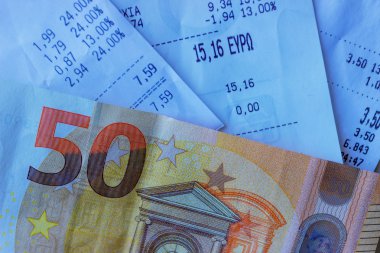 Bozuk paralar ve banknotlar birkaç makbuzda yatıyor. Seçici odak. Kavram - finans.