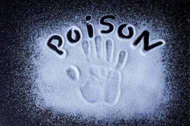 Tuz, şeker, siyah yüzeye serpilmiş. Yazılı kelime- zehir ve el izi. Kavram- sağlıklı gıda, diyet, tuz ve şeker aşırı tüketimi nden sağlığa zarar.