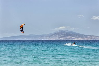  Denizde uçurtma uçurmak. Mavi gökyüzünde renkli uçurtmalar uçar. 