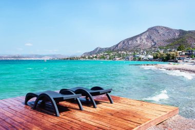 Rıhtımdaki güneş pansiyonları. Yunanistan 'daki Salamis adasının güzel manzarası.