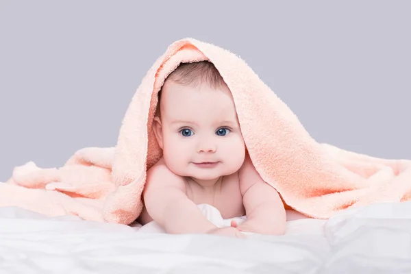 Bebek duş, gri arka plan üzerinde izole sonra göbek pembe havlu altında yatan büyük mavi gözlü