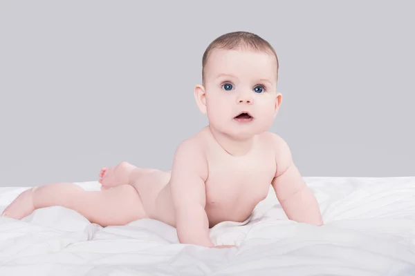 かわいい女の赤ちゃんまたは大きな青い目を持つ少年にある柔らかい毛布は 灰色の背景で隔離の裸 — ストック写真