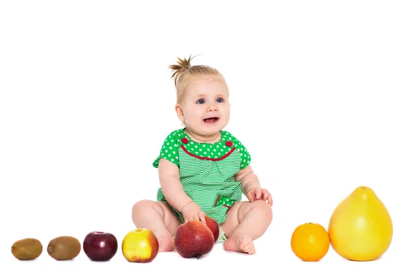 Baby Mädchen sitzt mit Obst und Gemüse, isoliert über whit — Stockfoto