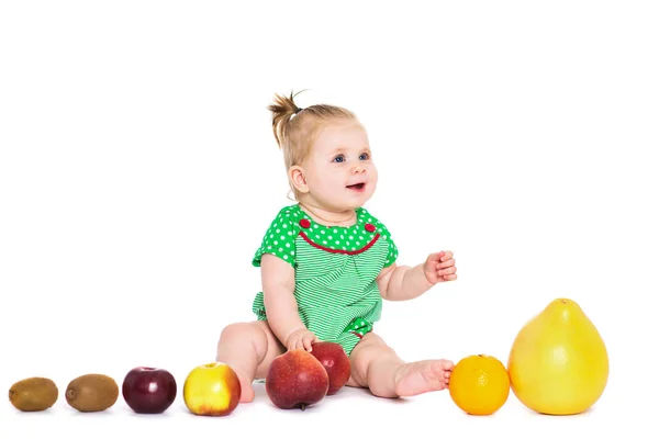 Baby Mädchen sitzt mit Obst und Gemüse, isoliert über whit — Stockfoto