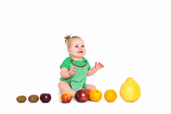 Девочка, сидящая с фруктами и овощами, изолированный бэкграун — стоковое фото