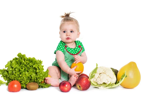 Девочка, сидящая в окружении фруктов и овощей, изолирована — стоковое фото