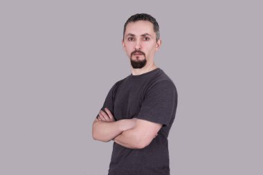 Çapraz kollarına gri arka planı olan bir adam portresi