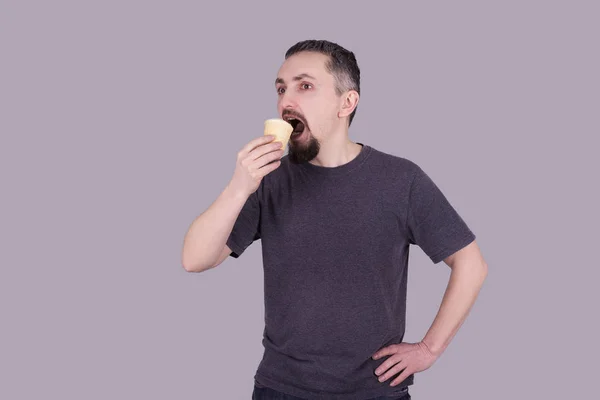 Człowieka z brodą, jedzenie lodów na szarym tle — Zdjęcie stockowe