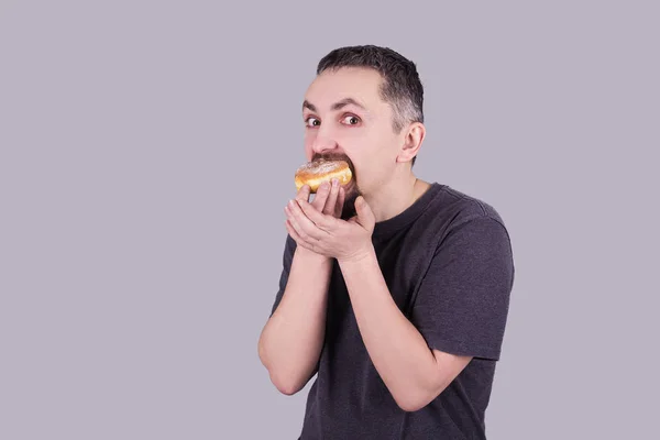 Bir sakallı bir topuz gri arka plan üzerinde yemek