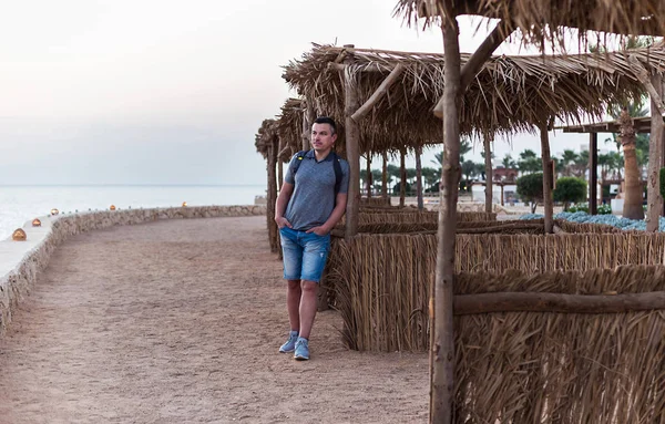 Sahilde sırt çantası ile gezgin adam