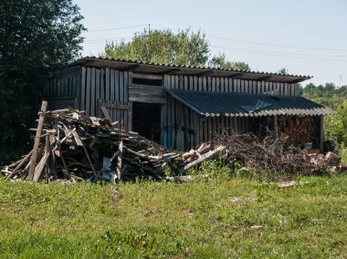 Ahır yakacak odun depolamak için ahşap panoları yapılır ve yeşil glade ve yakacak odun, panoları ve ağaçlar yalan için bir fırın köyde tür yan yana dalları üzerinde duruyor