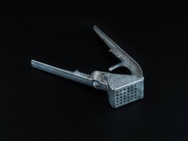 Sarımsak kapalı siyah bir arka plan üzerinde metal yalan şeklinde için tuşuna basın