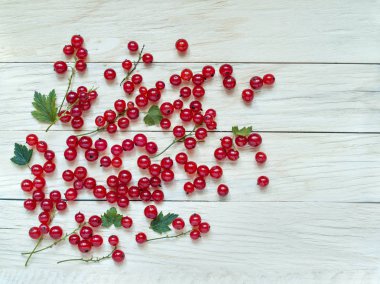 Çilek bir ahşap arka plan üzerinde dağılmış taze büyük kırmızı kuş üzümü yukarıda yakın çekim çekim