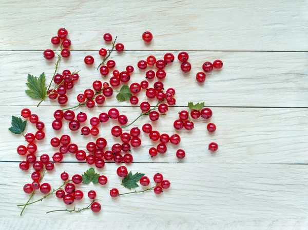 Çilek bir ahşap arka plan üzerinde dağılmış taze büyük kırmızı kuş üzümü yukarıda yakın çekim çekim
