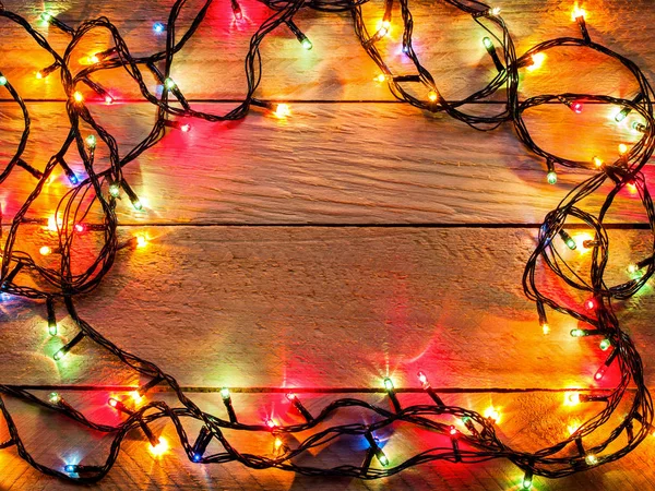 Multicolored Garland Glows Brightly Wooden Background Red Green Blue Yellow — Stock Photo, Image