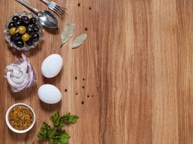 Zeytin, hardal, tavuk yumurtası, kırmızı soğan, defne yaprağı ahşap bir arka plan üzerinde yatay boşluk ile yalan