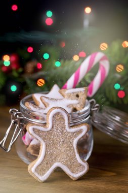 Ahşap arka plan şeker kamışı dikey şenlikli tonda Gingerbread çerezleri Gingerbread adam Noel gıda kart kavramı Noel ışıkları