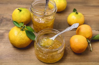 Lezzetli ev yapımı narenciye turuncu kavanoz reçel eski ahşap arka plan taze olgun narenciye üzerinde