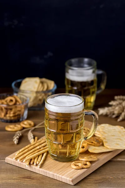 Cam fincan lezzetli Light bira ve ahşap masa Pretzel krakeri Solta dikey ile Snacks