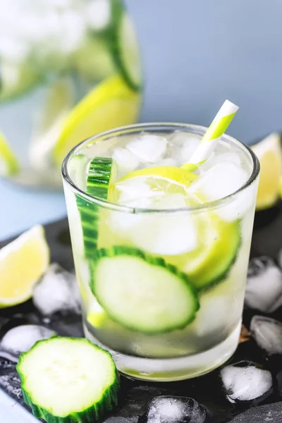 Agua desintoxicante infundida fría y refrescante con cal y pepino en un vaso con cubo de hielo Bebida desintoxicante saludable Vertical — Foto de Stock